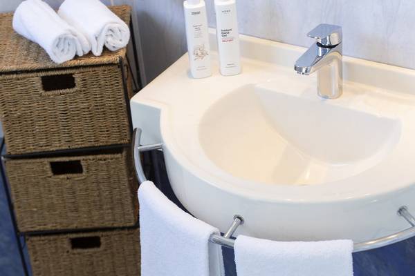 Badezimmer im Baia Imperiale Hotel mit Waschbecken, Handtüchern und Körperpflegeprodukten.