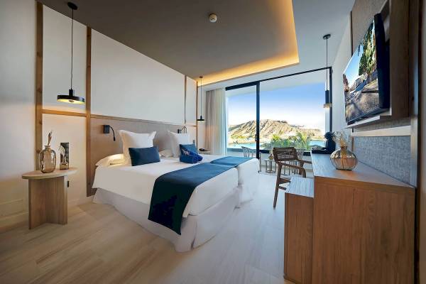 Doppelzimmer mit Meerblick im H10 Costa Mogan Hotel, mit zwei Betten, Blick auf das Meer und Berge.