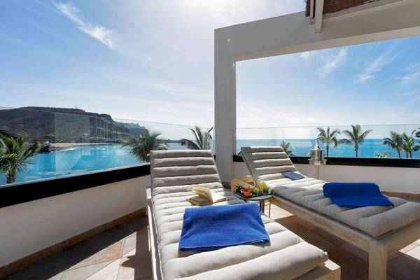 Balkon des H10 Costa Mogan Hotels mit Blick auf das Meer und Palmen.