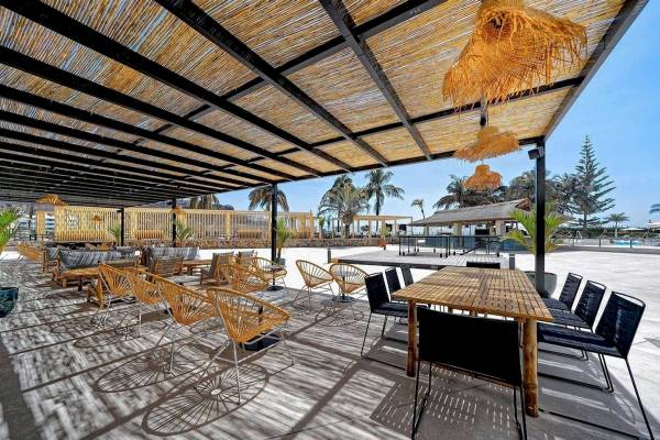 Außenterrasse des H10 Costa Mogan Hotels mit Möbeln und Blick auf Palmen