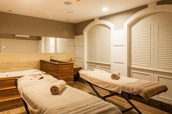 Massageraum im Belek Beach Resort Hotel mit zwei Massagetischen und einem Badewanne