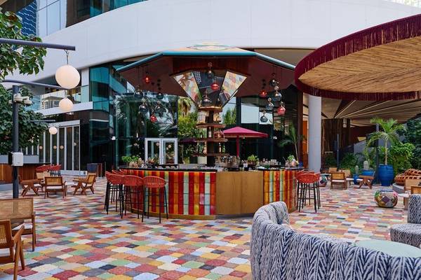 Hotelbarbereich im W Dubai - Mina Seyahi mit bunten Bodenfliesen und Möbeln.