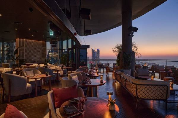 Innenbereich des W Dubai - Mina Seyahi Hotels bei Sonnenuntergang mit Blick auf die Stadt.