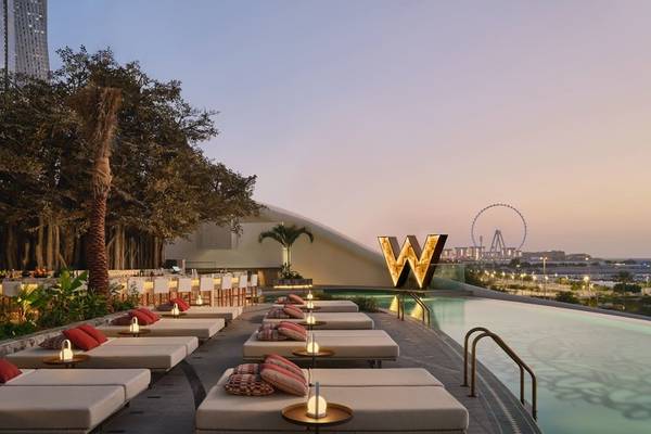 W Dubai - Mina Seyahi: Außenbereich des Pools mit Lounge-Sesseln und roten Kissen.