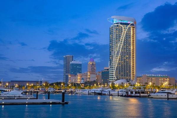 Das W Dubai - Mina Seyahi Hotel in der Stadt bei Nacht mit vielen Yachten im Hafen