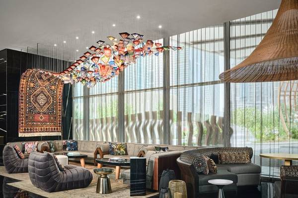 Innenansicht der Lobby des W Dubai - Mina Seyahi Hotels mit modernen Möbeln und farbenfrohem Teppich.