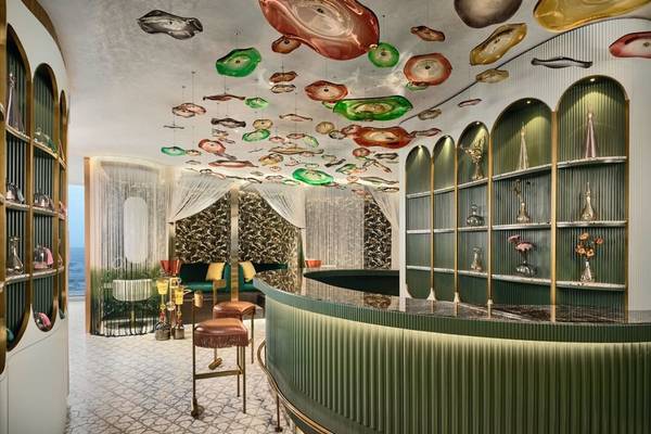 Inneneinrichtung des W Dubai - Mina Seyahi Hotels mit grünen Wänden und einer kunstvollen Decke.