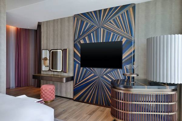 Hotelzimmer im W Dubai - Mina Seyahi mit geometrischen Wandmustern und modernen Möbeln.
