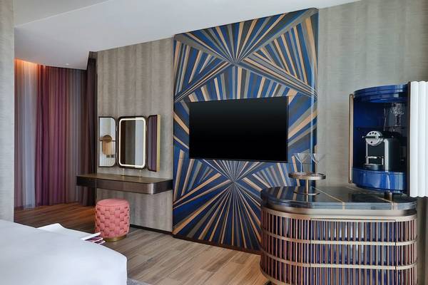 W Dubai - Mina Seyahi Hotelzimmer mit Fernseher, Deko und Esstisch