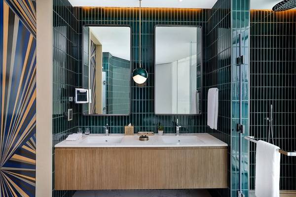 Badezimmer im W Dubai - Mina Seyahi Hotel mit grünen Fliesen und blauen Streifenmuster