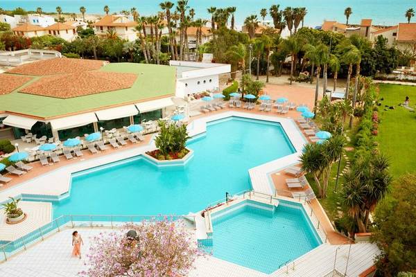 Luftaufnahme des Acacia Marina Hotels mit großem Swimmingpool und Sonnenschirmen.
