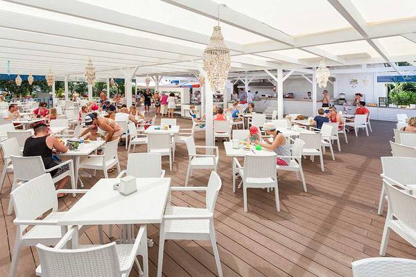 Terrasse im Freien des Belek Beach Resort Hotels mit vielen Gästen an Tischen.