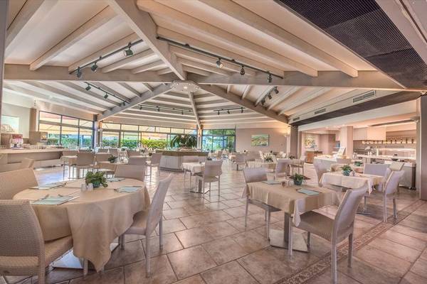 Innenansicht des Acacia Marina Hotels mit geräumigem Restaurant, gedeckten Tischen und moderner Einrichtung.