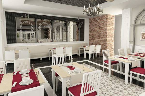 Innenansicht des Restaurants im Belek Beach Resort Hotel mit weißen Tischen und Stühlen, roten Sitzkissen, einer großen Spiegelwand und einer zentralen Kronleuchter.