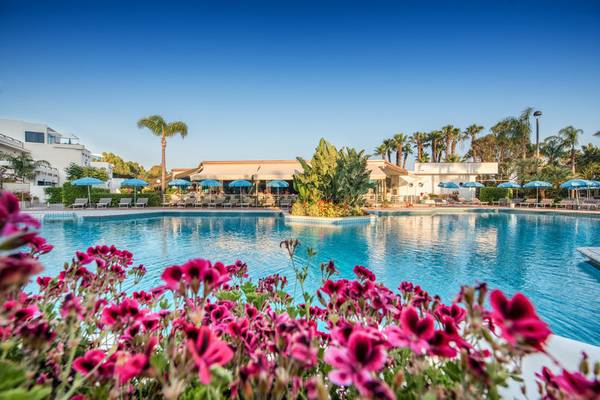 Außenpool des Acacia Marina Hotels mit Blumen und Sonnenschirmen