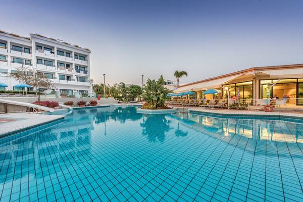 Außenpoolbereich des Acacia Marina Hotels mit blauem Wasser und Sonnenliegen.