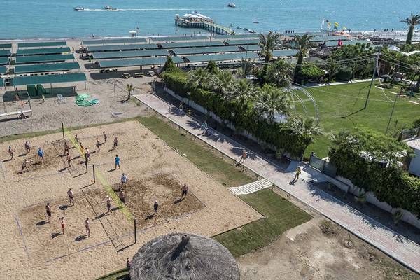 Luftaufnahme eines Volleyballspiels am Strand des Belek Beach Resort Hotels mit Blick auf das Meer und die Bucht.