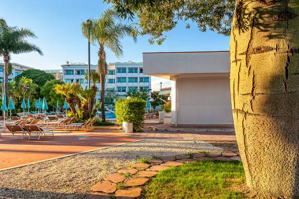 Loungebereich des Acacia Marina Hotels mit Sonnenliegen und Palmen