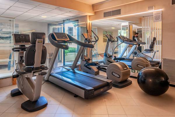 Fitnessstudio im Hotel Acacia Marina mit Laufbändern, Ellipsentrainern und einem großen schwarzen Medizinball.