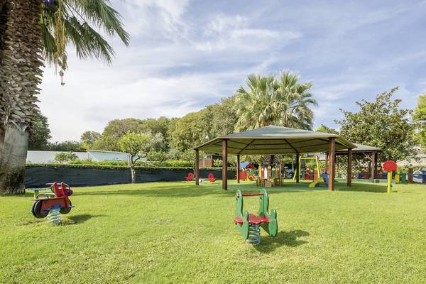 Kinderspielplatz im Freien im UNAHOTELS Naxos Beach Sicilia mit Spielgeräten und einem Pavillon.