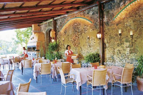 Restaurant im Freien mit Steinwänden im UNAHOTELS Naxos Beach Sicilia.