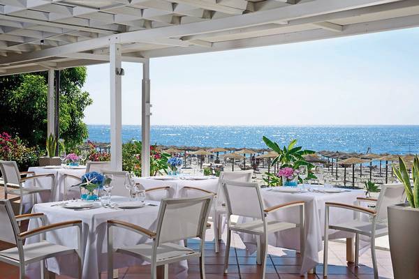 UNAHOTELS Naxos Beach Sicilia Terrasse mit Blick auf das Meer und die Strandschirme.
