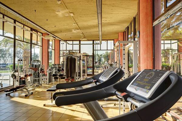 Fitnesscenter im UNAHOTELS Naxos Beach Sicilia mit Laufbändern und anderen Geräten.