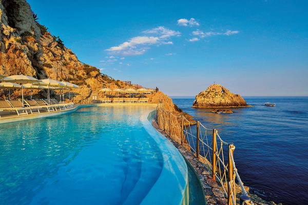 Außenpool des UNAHOTELS Capotaormina am Meerschliff mit Sonnenliegen und Sonnenschirmen