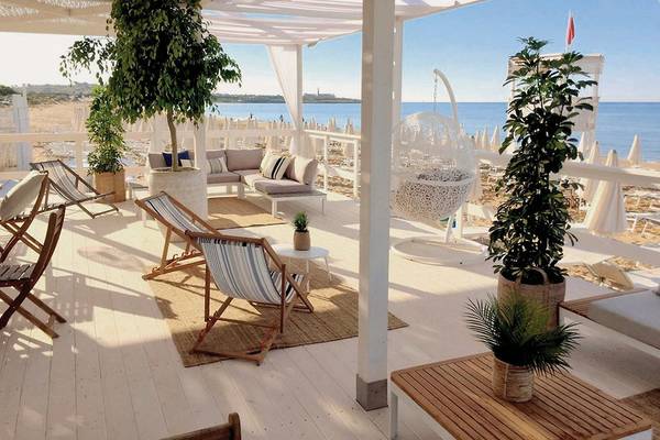 Terrasse des VOI Marsa Siclà Essentia Hotels mit Blick auf das Meer, Sesseln, Tischen und Pflanzen.