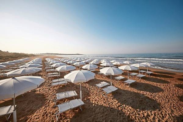 Strand des VOI Marsa Siclà Essentia Hotels mit vielen Sonnenschirmen und Liegen