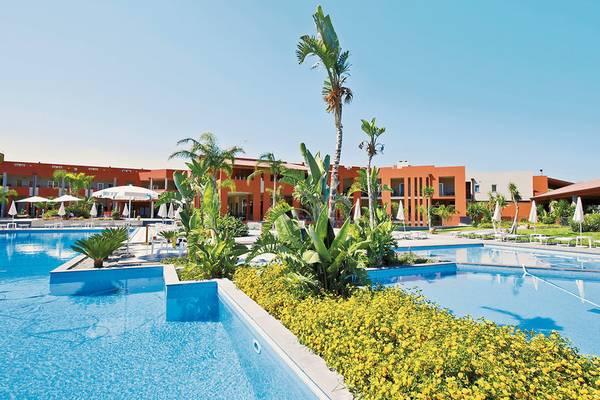 Außenpool des VOI Baia di Tindari Resorts mit orangefarbenen Gebäuden und Pflanzen
