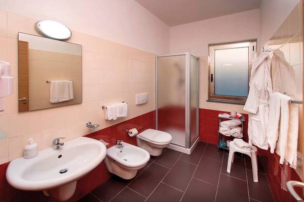 Badezimmer des VOI Baia di Tindari Resorts mit Bidet, Toilette, Dusche und Waschbecken.