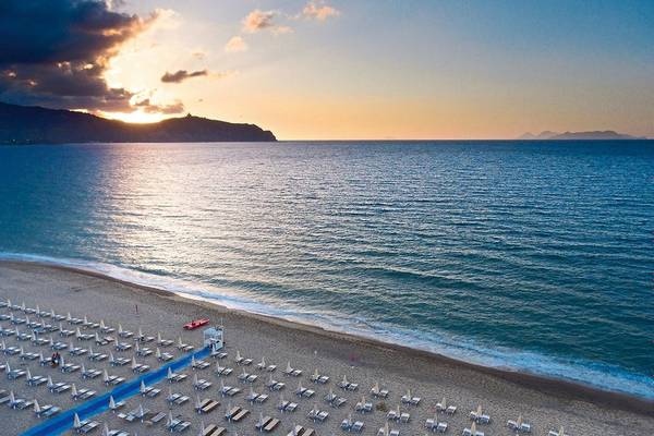 Luftaufnahme des Strandes des VOI Baia di Tindari Resorts mit vielen Liegestühlen und Sonnenschirmen am Meer