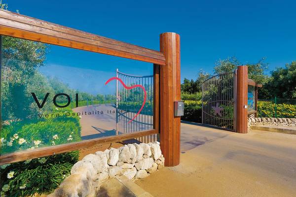 Eingang zum VOI Arenella Resort mit Holztor und VOI Logo