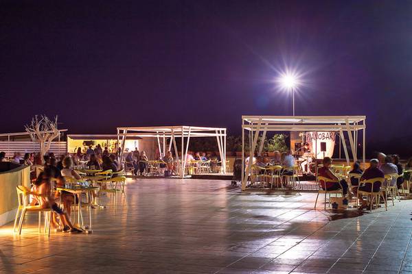 Abendveranstaltung im Freien im VOI Arenella Resort mit Gästen an Tischen und einer Bühne.