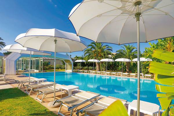 Außenpool des VOI Arenella Resorts mit Sonnenliegen und Sonnenschirmen.