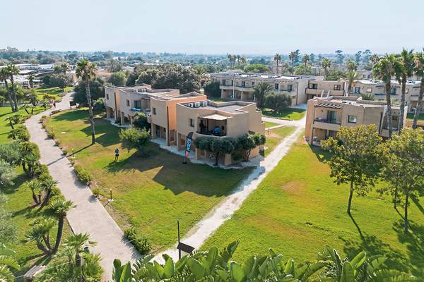 Luftaufnahme des VOI Arenella Resorts mit mehreren Reihen von Gebäuden und umliegenden Bäumen.
