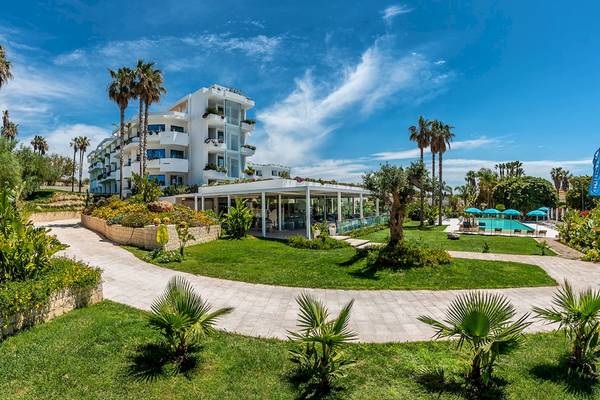 Außenansicht des Acacia Palace Hotels mit Pool und Sonnenschirmen