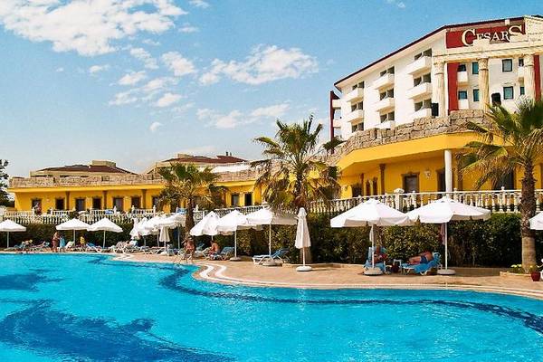 Poolbereich des Caesars Side Hotels mit Liegestühlen und Sonnenschirmen.