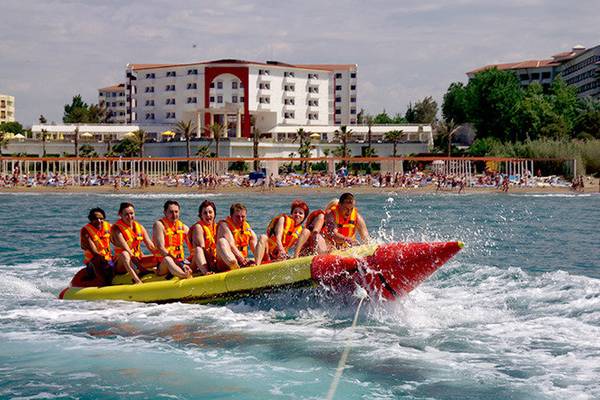 Gruppe von Personen im Cesars Side Hotel auf einer Bananenboot-Fahrt am Strand