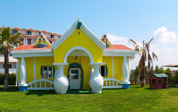 Gelbes charakteristisches Haus im Garten des Cesars Side Hotels