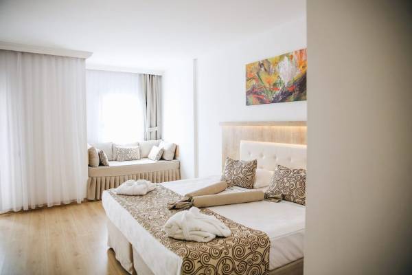Ein elegantes Hotelzimmer im Cesars Side Hotel mit einem Doppelbett und einem Schlafsofa.