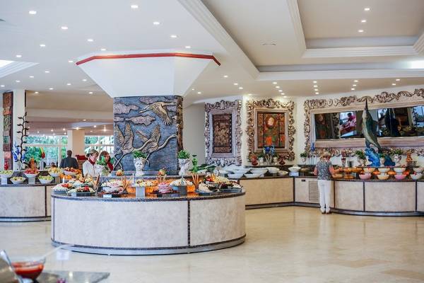 Buffetbereich im Cesars Side Hotel mit verschiedenen Speisen und einer Person, die bedient.