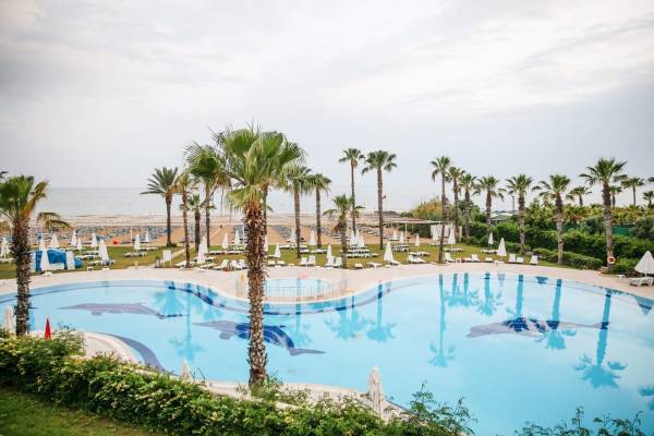 Poolbereich des Cesars Side Resorts mit Palmen und Sonnenliegen am Strand