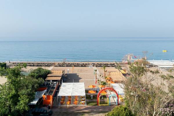 Ausblick auf den Strand des Megasaray Resort in Side mit Pavillons und Sonnenschirmen.