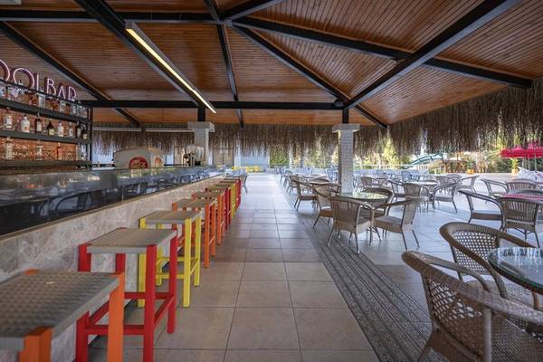Innenansicht der Bar des Megasaray Resort Side mit Thekenhockern, Tischen und Stühlen.