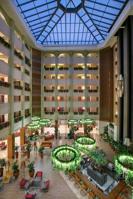 Innenansicht des Megasaray Resort Side Hotels mit Atrium, Pflanzen und Sitzbereichen.