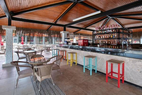 Innenansicht der Poolbar des Megasaray Resort Side mit Holzdecke, Bartheken und bunten Hockern.