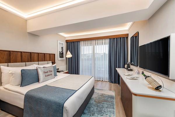 Seaden Quality Resort & Spa Hotelzimmer mit Bett, Fernseher und Schreibtisch