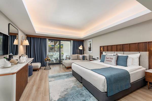 Hotelzimmer im Seaden Quality Resort & Spa mit großem Bett, Dekor und Ausblick auf den Pool.